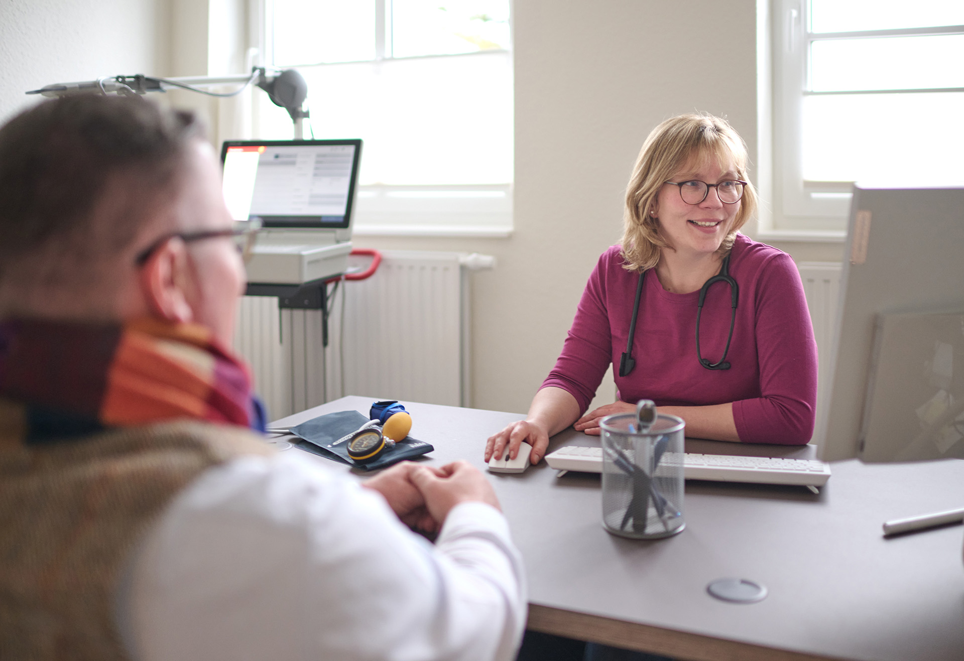 Gespräch zwischen Astrid Menzer und Patient in der Arztpraxis Altefeld